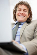 Happy businessman working on a laptop