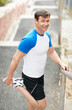 Fitness concept - Handsome man stretching outdoors