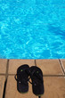 Badelatschen stehen am Pool