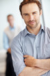 Smart man with hands folded and a blurred man in background