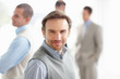Happy middle aged man with his colleagues in background