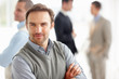 Confident middle aged man with coworkers in background