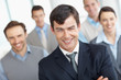 Happy middle aged man with his team in blurred background