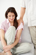 Man consoles a crying woman sitting on couch