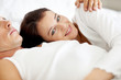 Young woman lying on bed with her husband