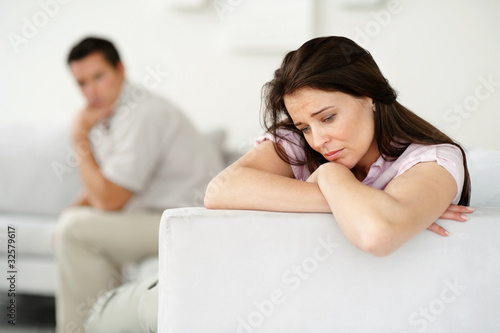 Foto: Relationship problem - Worried young couple sitting separately o Relationship problem - Worried young couple sitting separately o