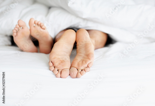 Foto: Feet of a couple resting on bed Feet of a couple resting on bed
