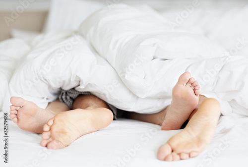 Photo: Couple acting naughty in bed Couple acting naughty in bed