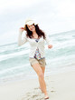 Happy young female doing catwalk on seashore