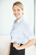 Smiling confident executive standing with hand on hip