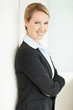 Happy confident young business woman in suit, hands folded