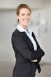 Smiling confident young business woman in suit with hands folded