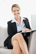 Successful smiling young business woman using a laptop