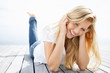 Cute young woman lying on a wooden porch
