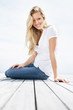 Pretty casual female sitting on a porch with a smile