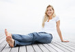 Pretty casual woman sitting relaxed on a wooden porch