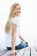 Happy young woman sitting on a wooden porch