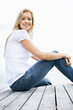 Smiling casual woman sitting on a wooden porch