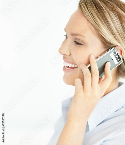 Photo: Side view of a happy young girl using cellphone with copyspace Side view of a happy young girl using cellphone with copyspace