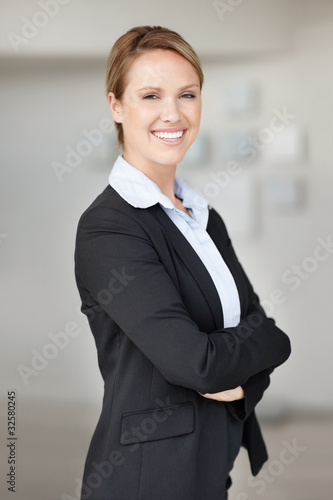 Photo: Smiling confident young business woman in suit with hands folded Smiling confident young business woman in suit with hands folded