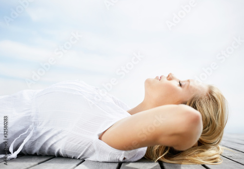Foto: Side view of a peaceful woman lying relaxed on a porch Side view of a peaceful woman lying relaxed on a porch