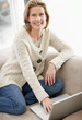 Happy mature woman working on a laptop at home
