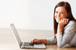 Photo: Beautiful woman using laptop and giving you a cute smile Beautiful woman using laptop and giving you a cute smile