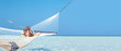 Happy woman relaxing on hammock at a beach