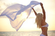 Young woman in bikini at the beach with a sarong
