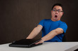 young asian man got his hands stuck in laptop computer