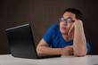 bored and tired young asian man working with his computer