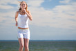 Sport woman running in sea coast