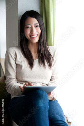 Photo: beautiful asian woman using a tablet computer beautiful asian woman using a tablet computer