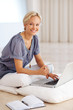 Happy woman enjoying  cup of coffee and using laptop