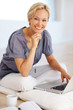 Young woman sitting on floor using laptop
