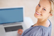 Happy young woman looking up with a laptop
