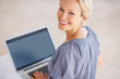 Smiling young woman sitting with a laptop