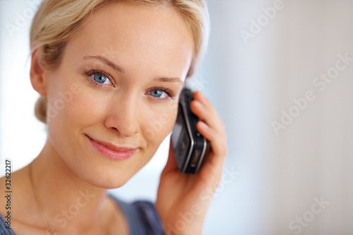 Foto: Portrait of a young woman using mobile phone Portrait of a young woman using mobile phone