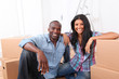 Cheerful couple sitting in empty new house