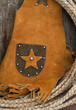 Western theme rope leather vest on old wood shelf