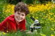 Boy using microscope outdoor