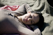 A young woman sleeping on a blanket, outdoors