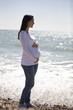 Portrait of a pregnant woman standing on the beach