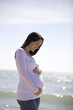 Portrait of a pregnant woman standing on the beach
