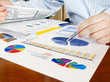 Male hand with pen on the investment charts. Male hand with pen on the investment charts.