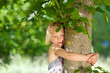 mädchen umarmt einen baum
