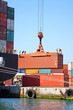 Freight container hanging on crane at sea port