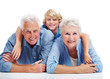 Happy old couple lying on floor with a their grandson