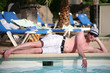 Porträt einer schönen jungen Mann liggen am Rand eines Pools