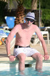 Foto: Porträt einer schönen jungen Mann sitzen am Rand eines Pools Porträt einer schönen jungen Mann sitzen am Rand eines Pools